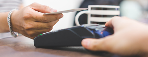 Shopper making a payment by tapping their tap-and-go card on the pay point instead of inserting it.