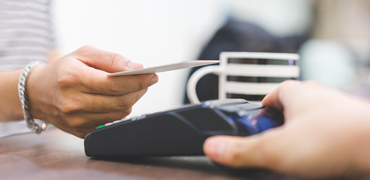 Shopper making a payment by tapping their tap-and-go card on the pay point instead of inserting it.